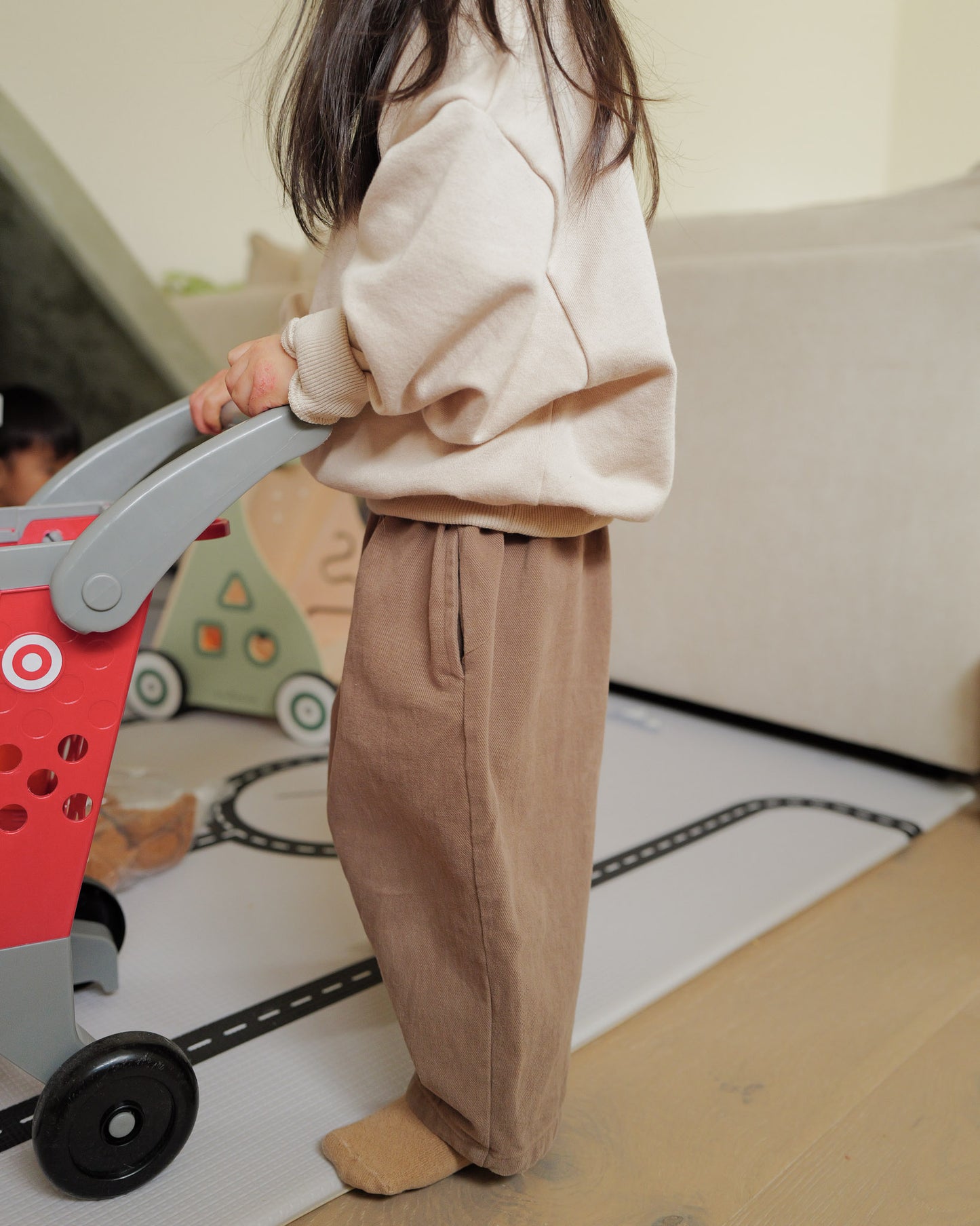side profile girl in oori noa's brown cotton barrel trousers