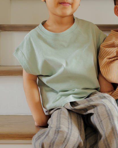 boy sitting in cut off tee sage