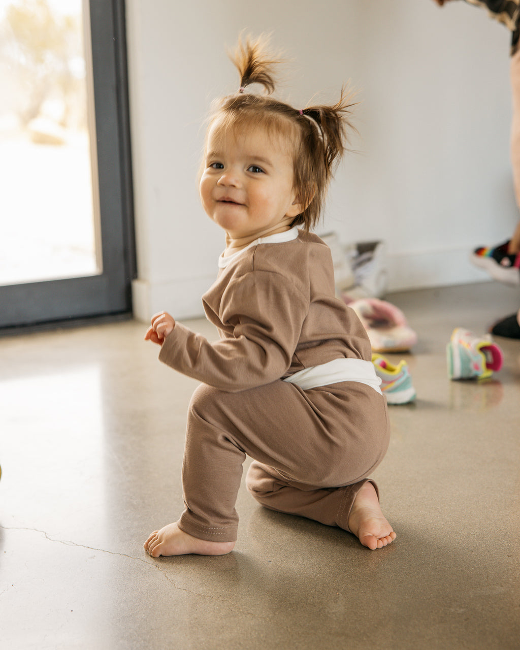 baby smiling wearing oori noa's cotton body suit and pant set