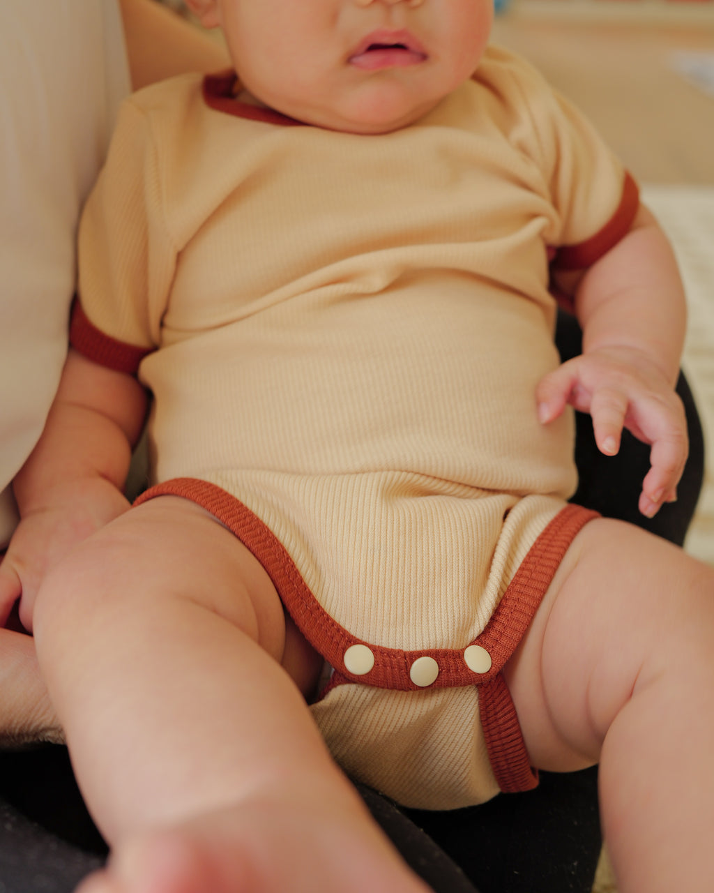 infant in ribbed short-sleeve onesie beige