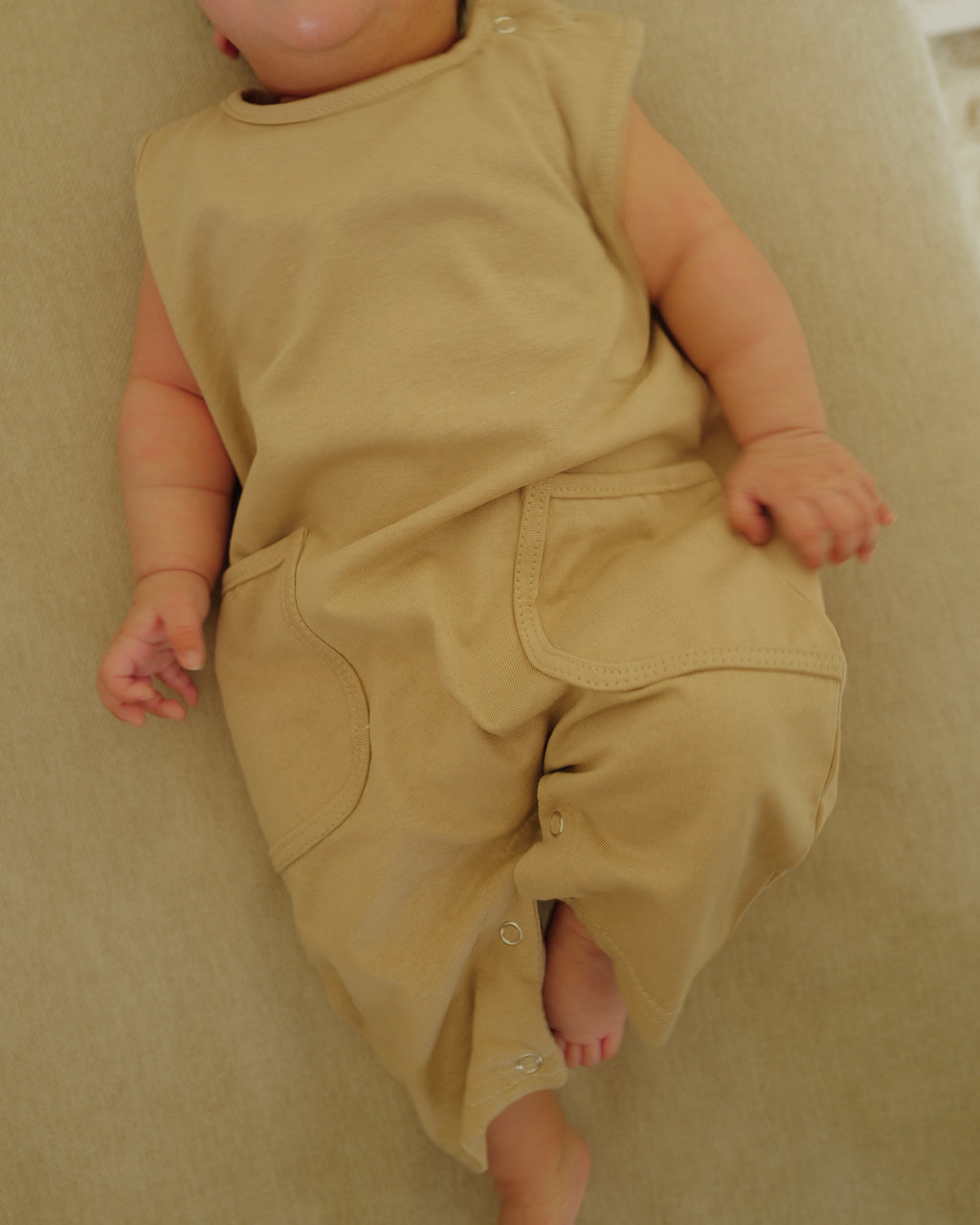 infant in summer romper beige