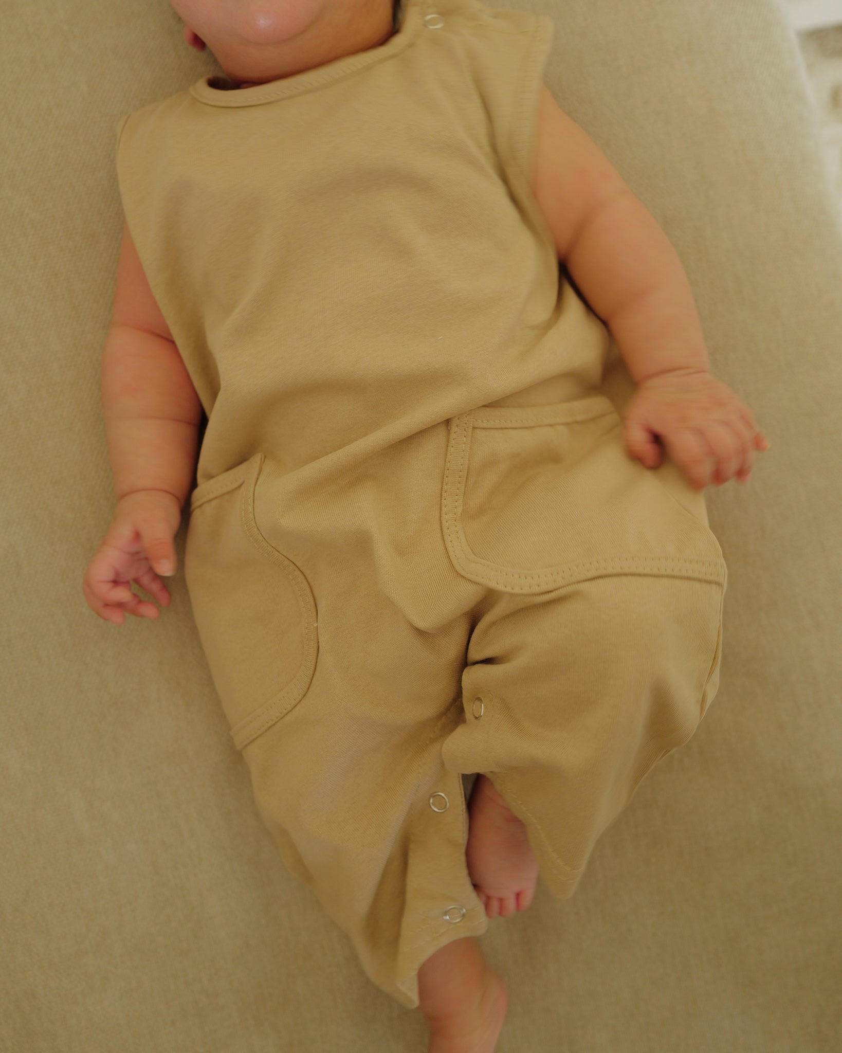 infant in summer romper beige