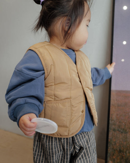 toddler girl in light puffer vest