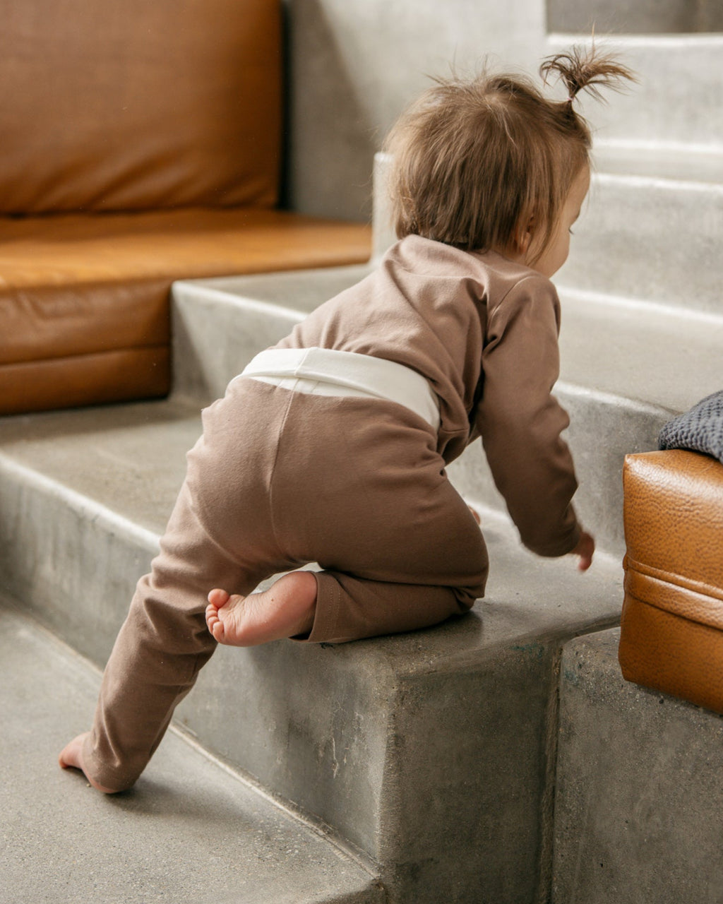 baby climbing stairs wearing brown cotton baby 2-piece from oori noa